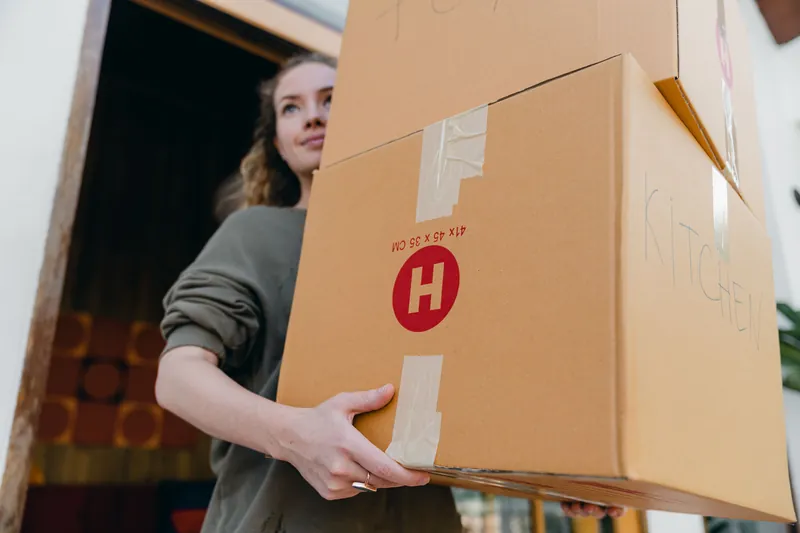 Woman carrying moving boxes for a move-out cleaning in Naperville